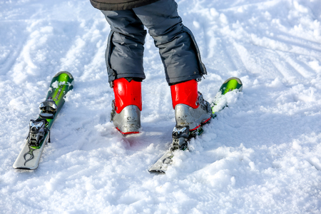 GERARDMER, FRANCE - FEB 16 - Young child putting on his ski in snow during the annual winter school holiday on Feb 16, 2015 in Gerardmer, France.のeditorial素材
