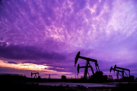 Silhouette of Oil pumps at oil field with nice sunset sky backgroundの写真素材
