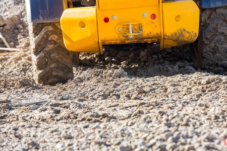 Bulldozer with huge tyres working on a construction site in the afternoon