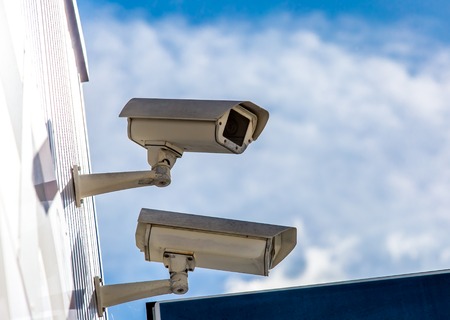 closeup on two security CCTV cameras or surveillance system in office building