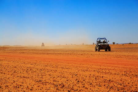 Merzouga, Morocco - Feb 23, 2016: Side view on blue Polaris RZR 800 with it's pilots in Morocco desert near Merzouga. Merzouga is famous for its dunes, the highest in Morocco.のeditorial素材