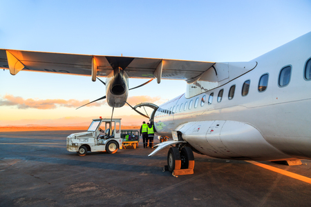 Ouarzazate, Morocco - Feb 28, 2016: agents of the airline charges passengers' luggages in the hold of the airliner at daybreakのeditorial素材