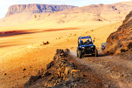 Merzouga, Morocco - Feb 21, 2016: blue Polaris RZR 800 crossing a mountain road in the Moroccan desert near Merzouga. Merzouga is famous for its dunes, the highest in Morocco.のeditorial素材