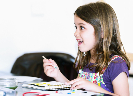 Expressive portrait of a pretty young girl doing paintの写真素材