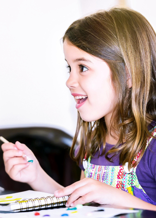Expressive portrait of a pretty young girl doing paint