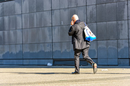 La defense, France- April 10, 2014: side view of businessman walking by telephoning in a streetのeditorial素材