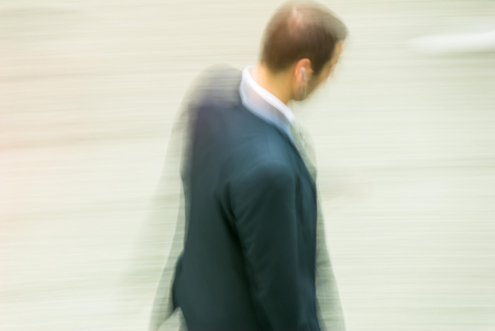 blurry to view of businessman walking in a streetの写真素材