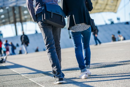 La defense, France- April 09 2014: Stylish young couple walking in a street. They both wearing blue jeans and sport shoesのeditorial素材