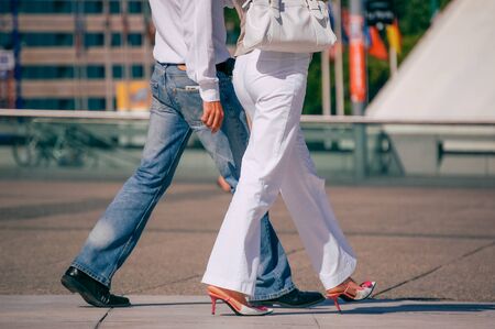 La defense, France - August 30, 2006:Stylish couple walking in a street. The man is wearing blue jean's and the woman white pant and pretty shoes feetのeditorial素材