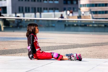 La defense, France- August 30, 2006:Child sitting on the floor with rollerbladingのeditorial素材