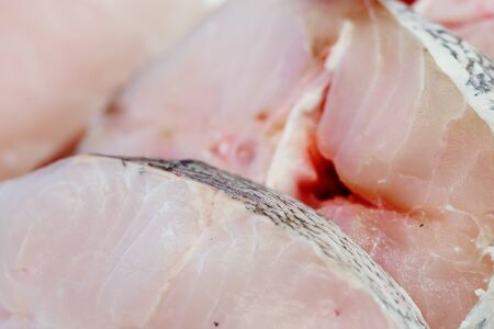 fresh pieces of hake on showcase of seafood marketの写真素材
