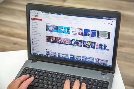 Paris, France - January 27, 2017 : Man using a laptop to connect to YouTube website home page. YouTube is a video-sharing website, created by three former PayPal employees and owned by Google.のeditorial素材