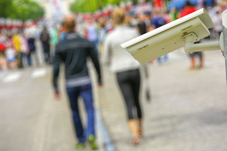 security CCTV camera or surveillance system with lovers and the crowd on blurry background