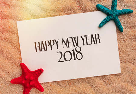Happy New year background with sea star on a sand background