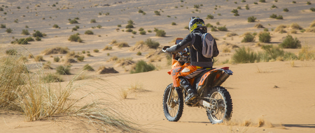 Ait Saoun, Morocco - February 25, 2016: back vue of man in helmet riding bike in Ait Saoun desert of Moroccoのeditorial素材