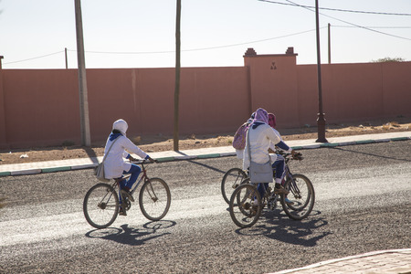 Ait Saoun, Morocco - February 23, 2016: Woman riding bicycle on a sunny morning in a Ait Saoun village in southern Morocco.のeditorial素材