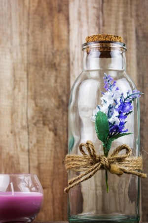 Closeup on glass bottle and decorative candle with wood in the background. Beauty Spa Health and Wellness concept.の写真素材