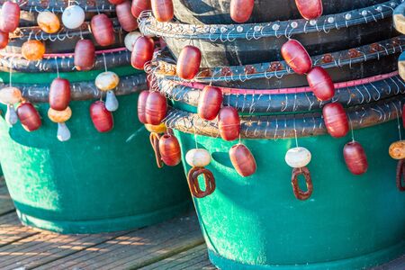 Lobster traps standing on a pier prepared for fishing with ropes and buoysの写真素材