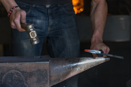 closeup on farrier making a traditional horseshoe on a forgeの写真素材