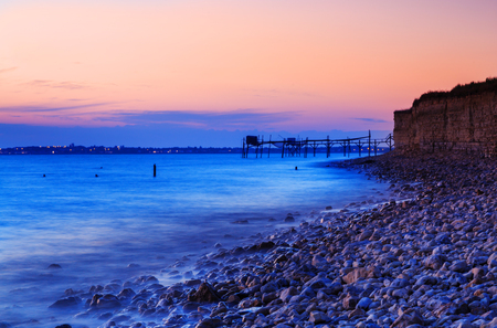 Beautiful sunset on the seashore with fishing huts in the backgroundの写真素材