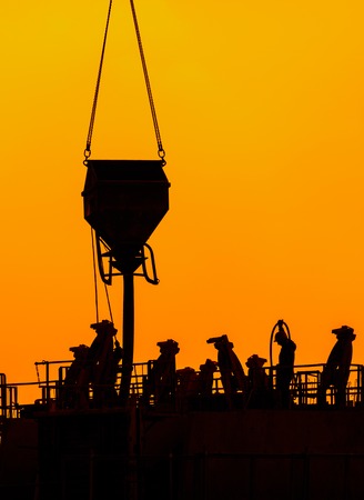 building workers working on a building under a beautiful sunset. Chinese shadow effect.の写真素材