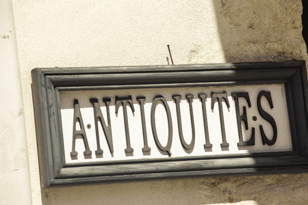 view of slanted closeup of sign - "Antiques" ("Antiquites" in French).の写真素材