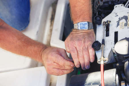 Ile de re, France - August 22, 2016 : Closeup of senior mechanic hands repairing boat engine at Ile de re, France, near La Rochelle.のeditorial素材