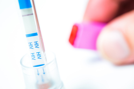 HIV self-test with seronegative result and its lancing device on white backgroundの写真素材