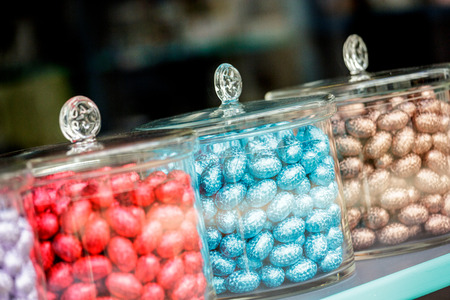 Close up of three glass jars full of mini easter eggs