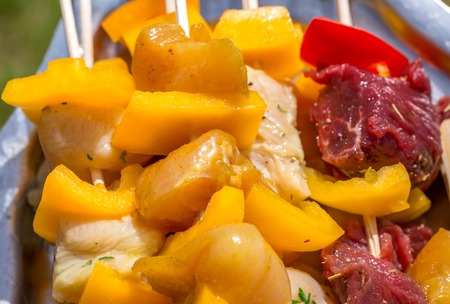 closeup of Raw chicken and beef skewers resting on a trayの写真素材