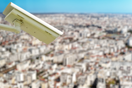 security CCTV camera or surveillance system with town on blurry backgroundの写真素材