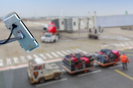 Focus on security CCTV camera or surveillance system with airport tarmac on blurry background