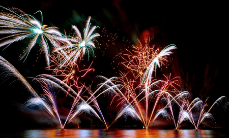 Brightly Colorful Fireworks shot over the sea. Celebration day