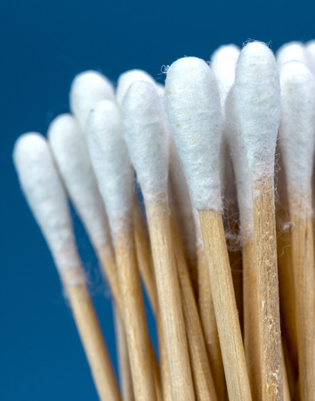 close up on wood cotton buds isolated on blue backgroundの写真素材