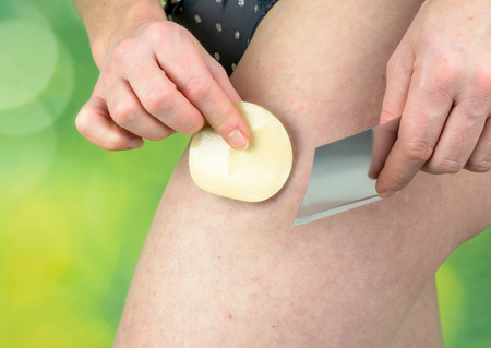 Attractive healthy woman applying a nicotine patch on her thighの写真素材