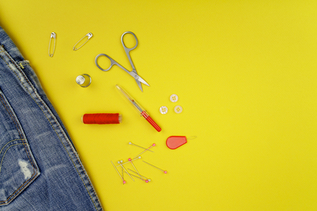 Multiple accessories for sewing view from above on a yellow background. clothing manufacturing concept, retouching, repair, fashion design, passion or fashion tradeの写真素材