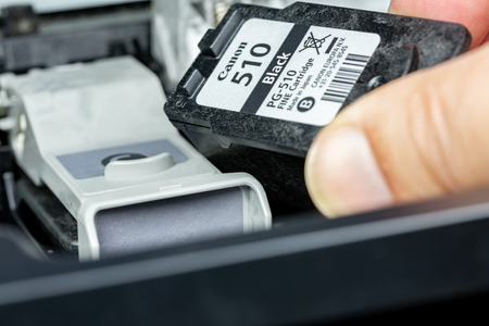 Benon, France - January 15, 2019: close up on Canon 510 Black ink cartridge replacement cartridges by one hand of a man on an inkjet printerのeditorial素材