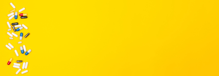 Panoramic Top view of pills or drugs spilled on a colored backgroundの写真素材