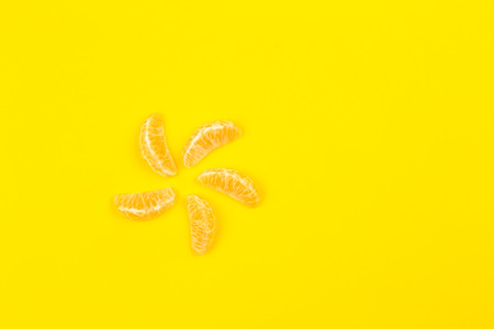 slices of mandarin or tangerine with leaves isolated on yellow background. Flat lay, top view. Fruit...
