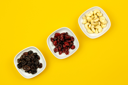 Raw Vegan breakfast: assorted dry fruits on yellow backgroundの写真素材
