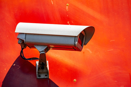 Security CCTV camera installed on a red wall in the cityの写真素材