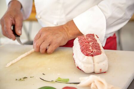closeup of butcher preparing a rosbeef on his work planの写真素材
