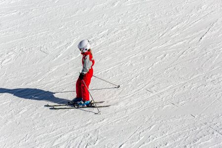 La Mongie, France - March 21, 2019: Child skiing in mountains. Active toddler kid with safety helmet, goggles and poles. Winter sport for family. Kids ski lesson in alpine school. Little skier racing in snowのeditorial素材