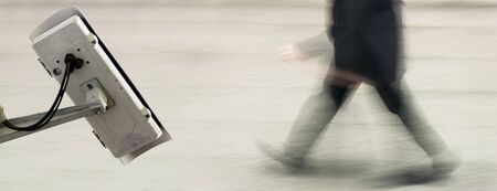 CCTV camera concept with business man in the street on blurry background