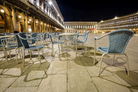 Venice, Italy - March 19, 2015:Night view of the Piazza San Marco showing a multitude of empty chairs belonging to a renowned bar. There are no more tourists on the square that has become desertedのeditorial素材