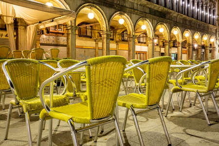 Venice, Italy - March 19, 2015:Night view of the Piazza San Marco showing a multitude of empty chairs belonging to a renowned bar. There are no more tourists on the square that has become desertedのeditorial素材