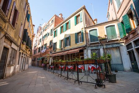 Venice, Italy - March 19, 2015: View to a closed restaurant with no one on the street on a small square in Venice, Italyの写真素材
