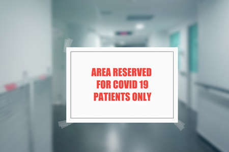 Sign on the door of a hospital corridor indicating an access area reserved for patients with covid-19 or coronavirusの写真素材