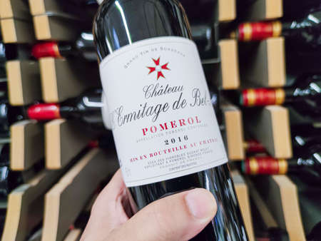 Builboreau, France - October 14, 2020: Closeup of Man hand buying a Pomerol Classified Growth bottle, a great French bordeaux wine in supermarketのeditorial素材