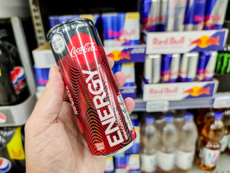 Puilboreau, France - October 14, 2020: Closeup of Man hand buying Can of Coca cola Energy Drink sugar free display for sell in the supermarket shelves. Coca cola energy is the new energy drink manufactured by coca cola companyのeditorial素材